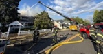 Fire crews work to control a large house fire in Auburn